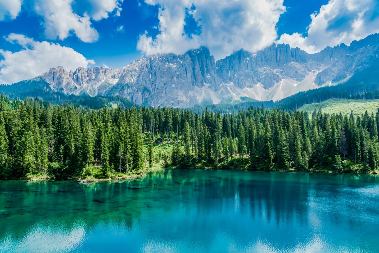 Breathtaking view of Italian alpine lake with majestic mountains and lush forest.